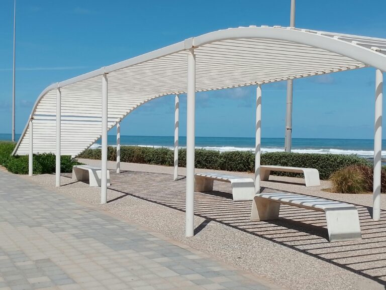 A sleek pergola with benches by the Casablanca ocean, perfect for sunny relaxation.